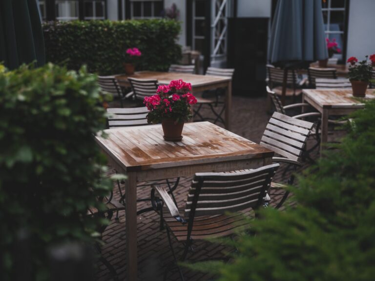 Charming outdoor cafe with wooden tables, chairs, and flower pots in Lage Vuursche, Netherlands.