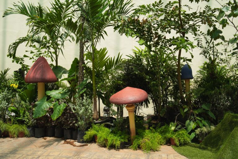 Colorful garden with large mushroom sculptures and tropical plants in Merida, Mexico.