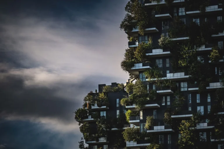 Innovative green architecture featuring lush plants growing on a modern urban skyscraper facade.