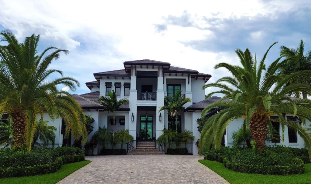 A stunning modern residential building with palm trees and clean architectural design.